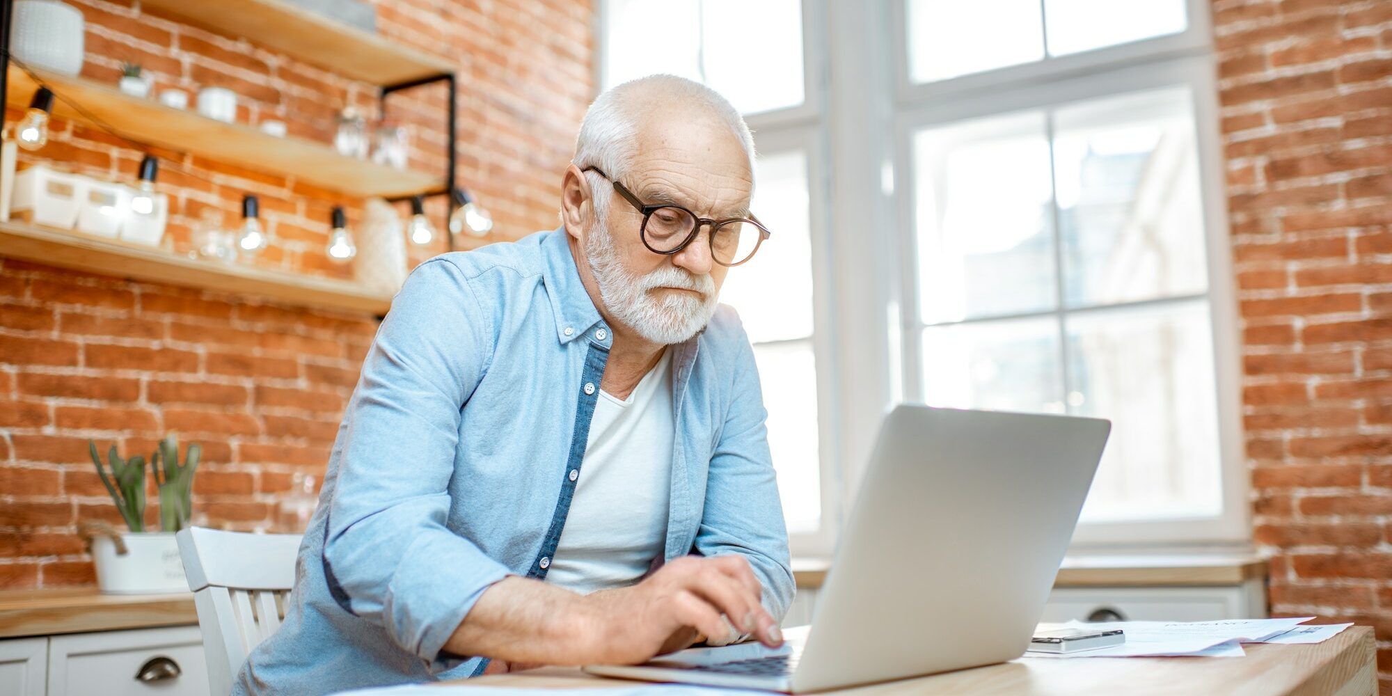 Senior man with laptop at home