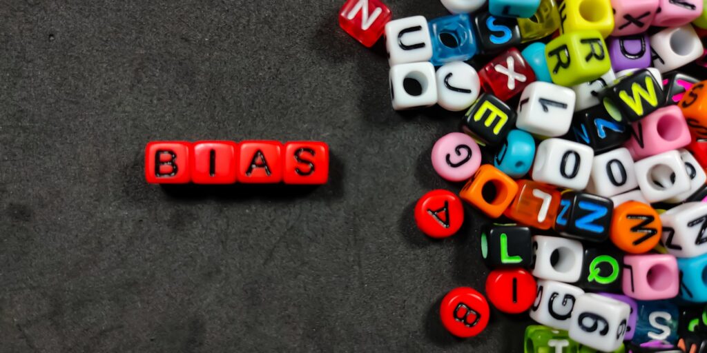 Selective focus.Colorful dice with color letter in word BIAS on black background.