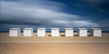 Long exposure of a row of beach huts on the beach of the North Sea in Koksijde, Belgium