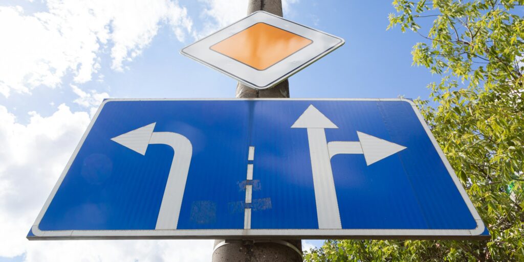 Bottom view of roadsign main road with tablet with direction allowed on crossroads against sky