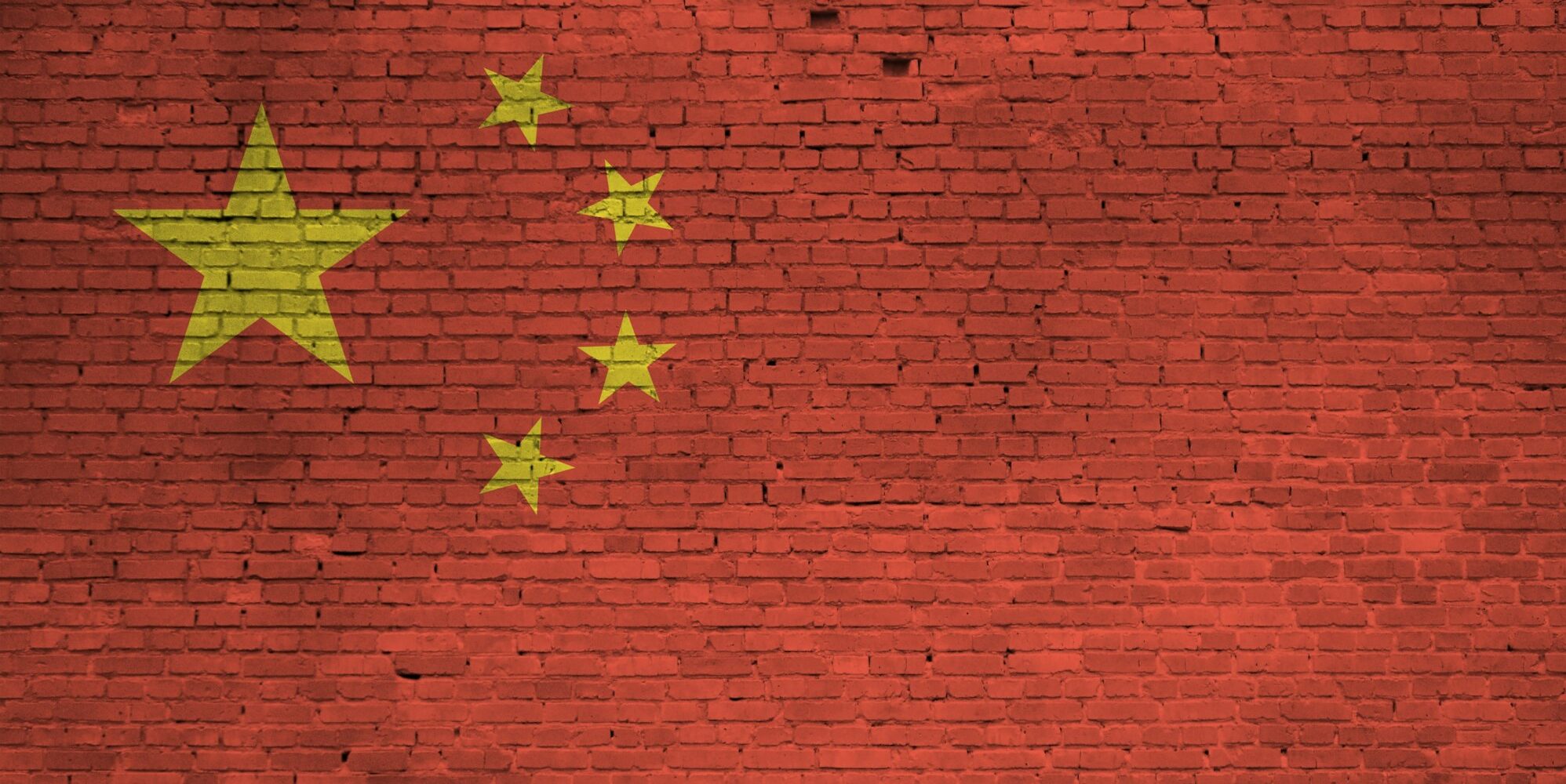 China flag depicted in paint colors on old brick wall close up