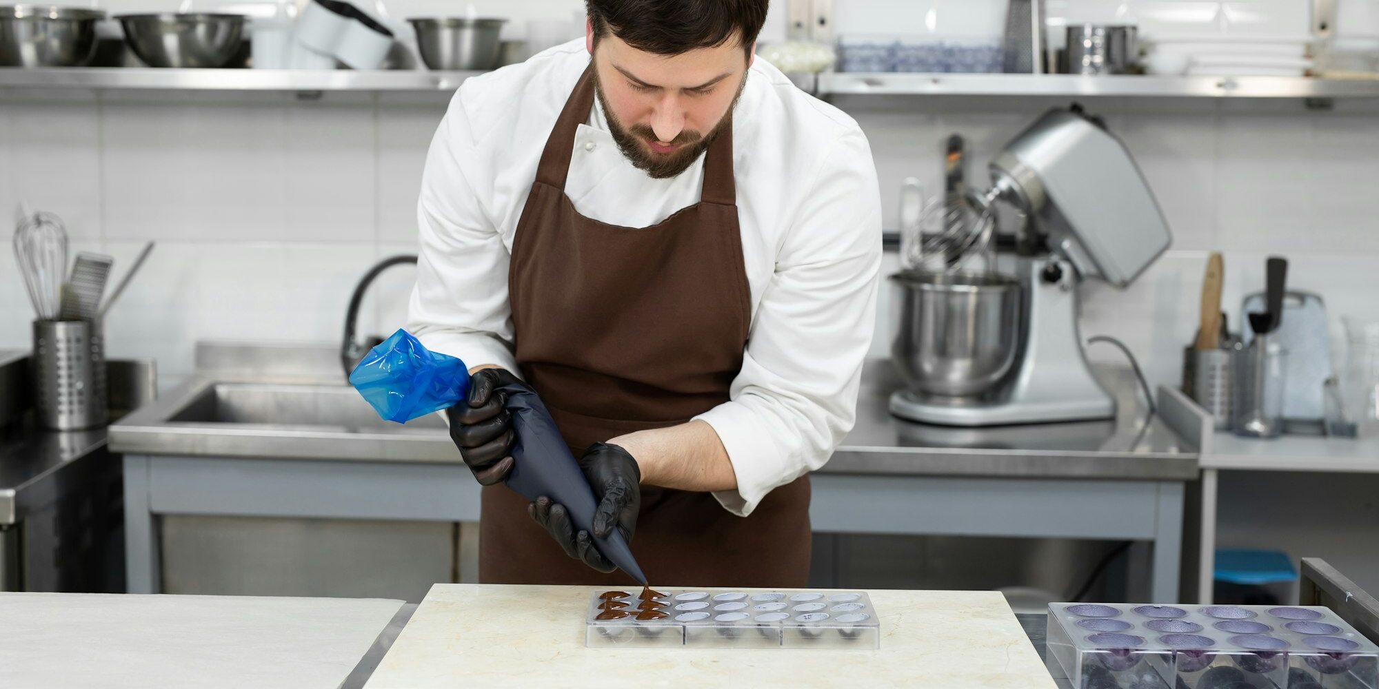 Chocolatier pours the chocolate into the molds.