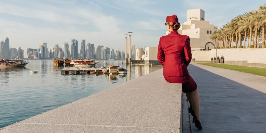 View from the back at unrecognisable cabin crew, looking at the skyline of Doha, Qatar, sunny day