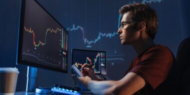 Man trader analyst at working table, analyzing financial chart, stock quotes, share prices, trading